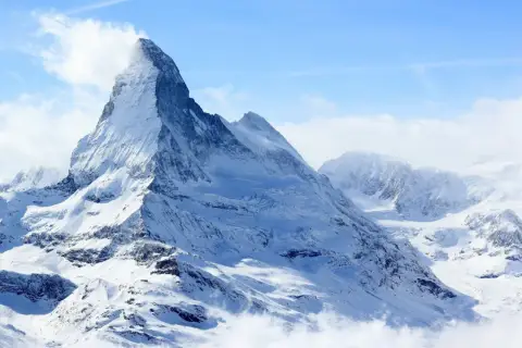 Majestatyczny szczyt Matterhorn, korona Europy, w otoczeniu innych ośnieżonych gór.